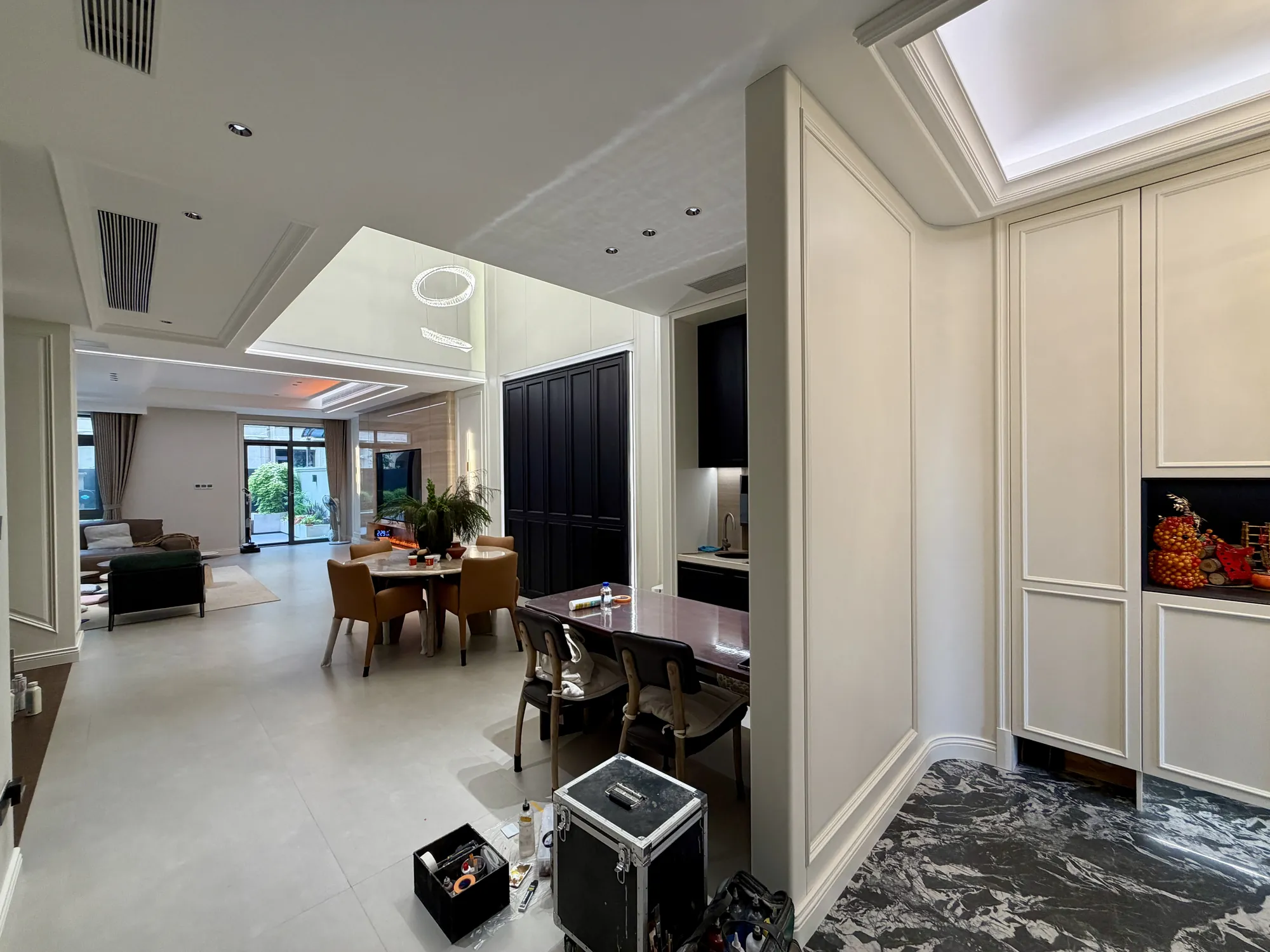 Open living and dining area with ivory joinery and dark doors