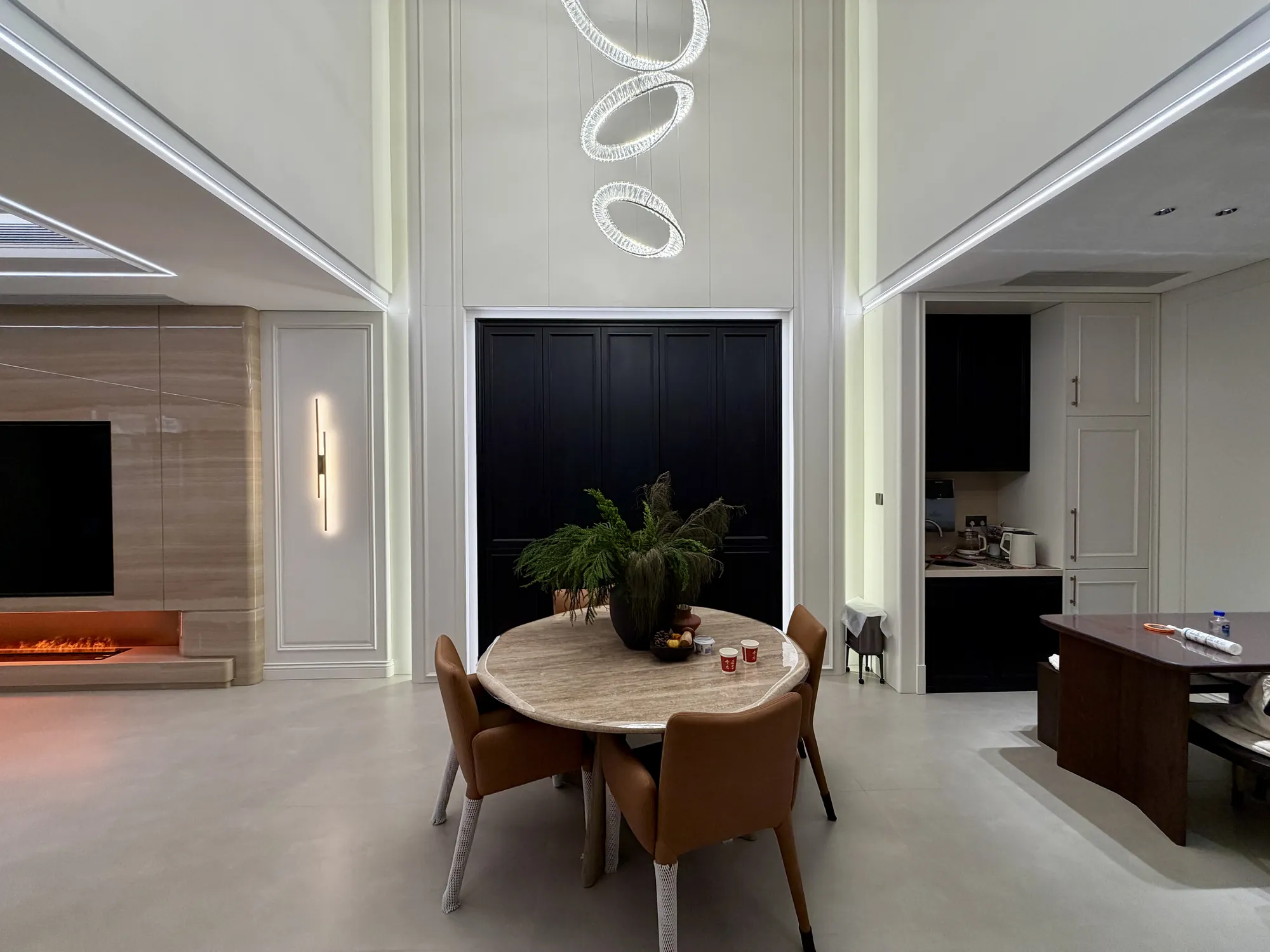 Rounded dining area with sculptural pendant and contrasting cabinetry