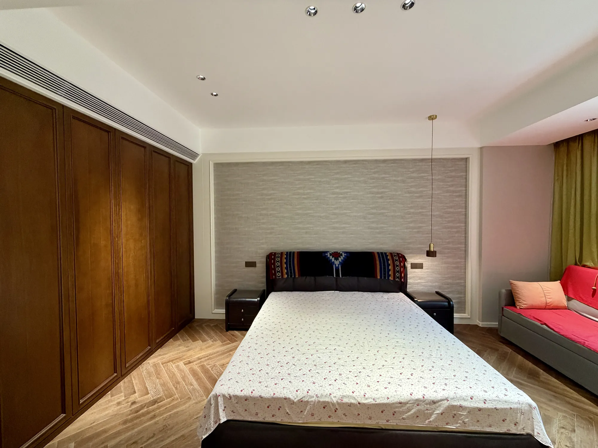 Bedroom with full-height walnut joinery and upholstered bed