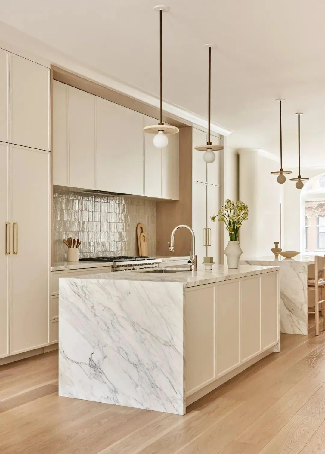 Warm-cream kitchen island with marble surface and pendant lighting