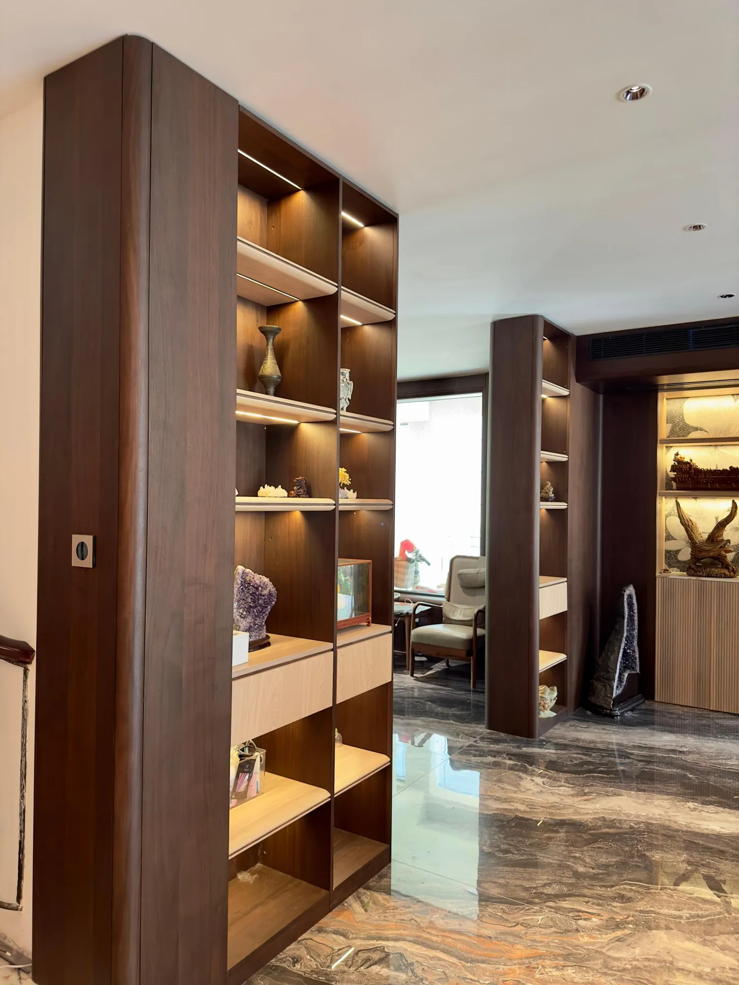 Open shelving partition with dark recesses and warm integrated lighting