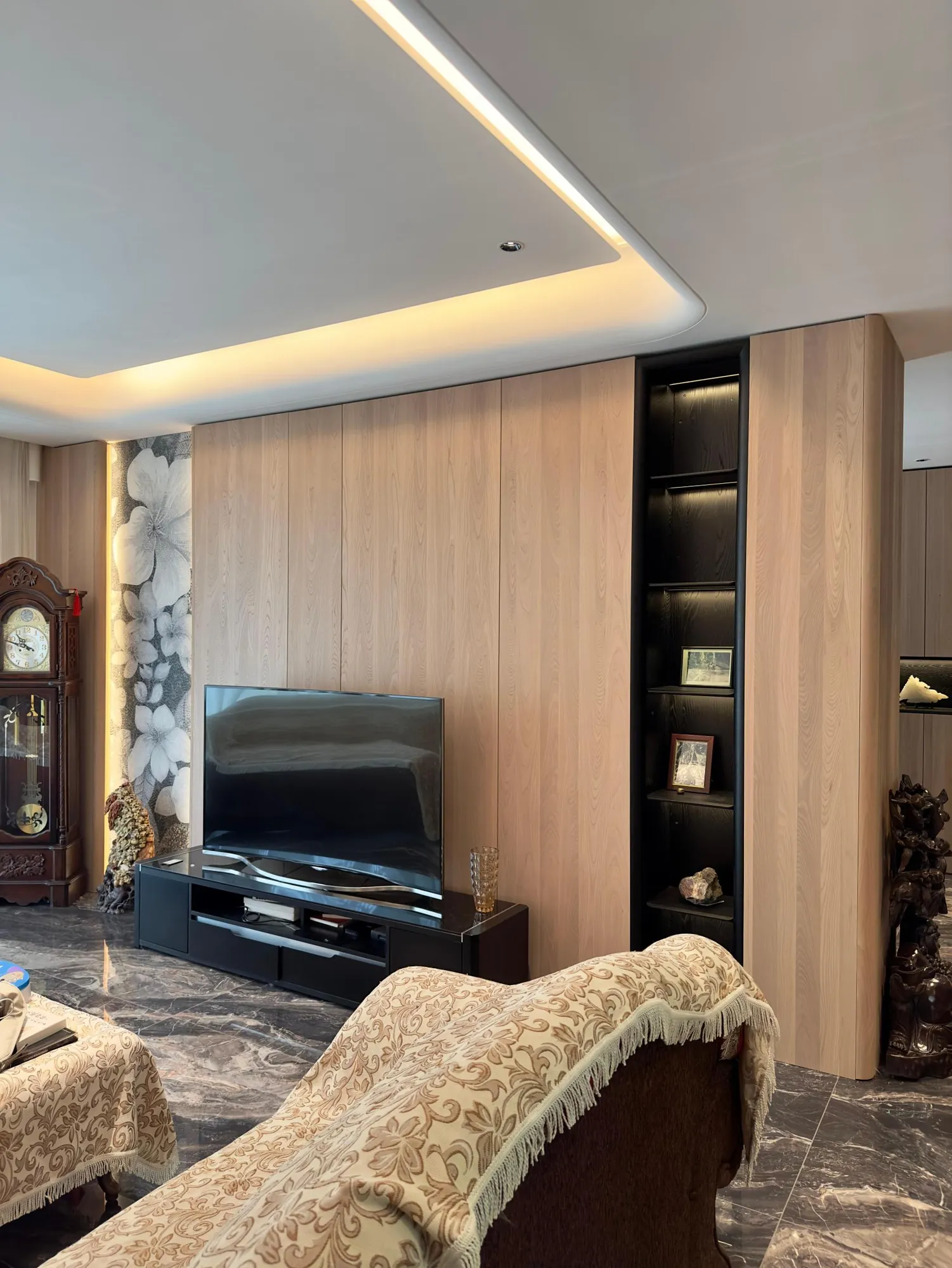 Light timber media wall with concealed storage and integrated display shelf