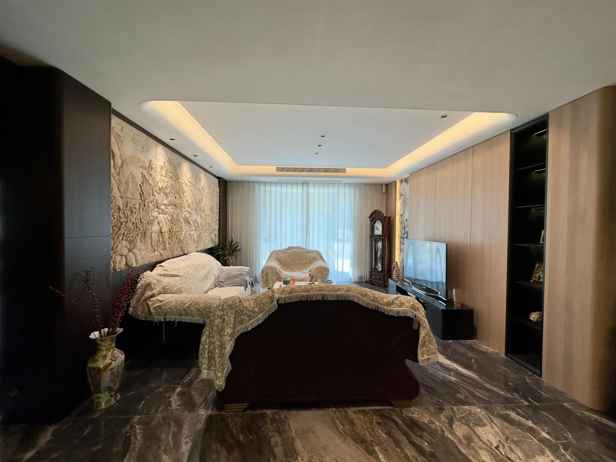 Wide living room view with pale fitted media storage and open seating area