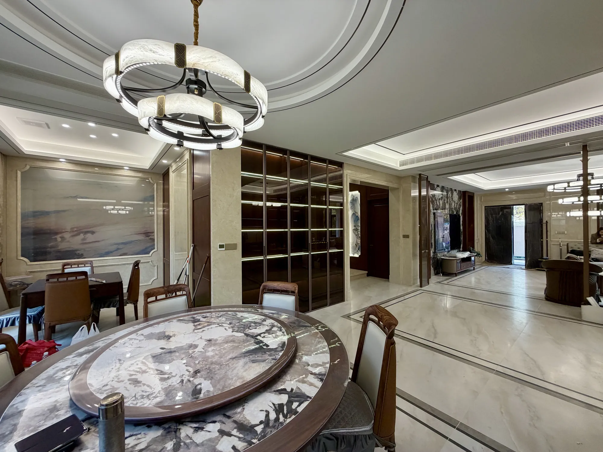 Formal round dining table beneath a layered classic chandelier