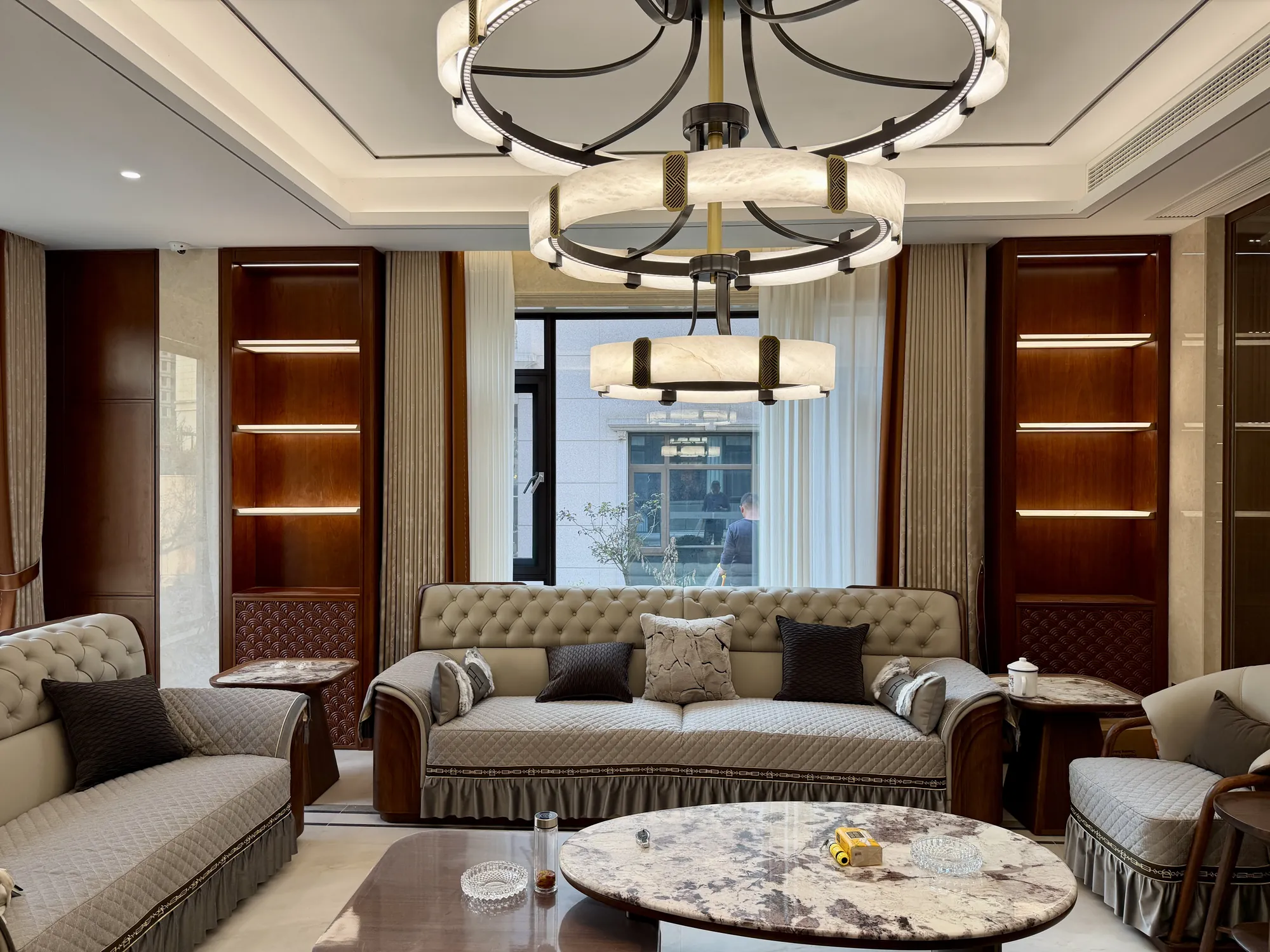 Wide living room with symmetrical seating, walnut panels and stone media wall