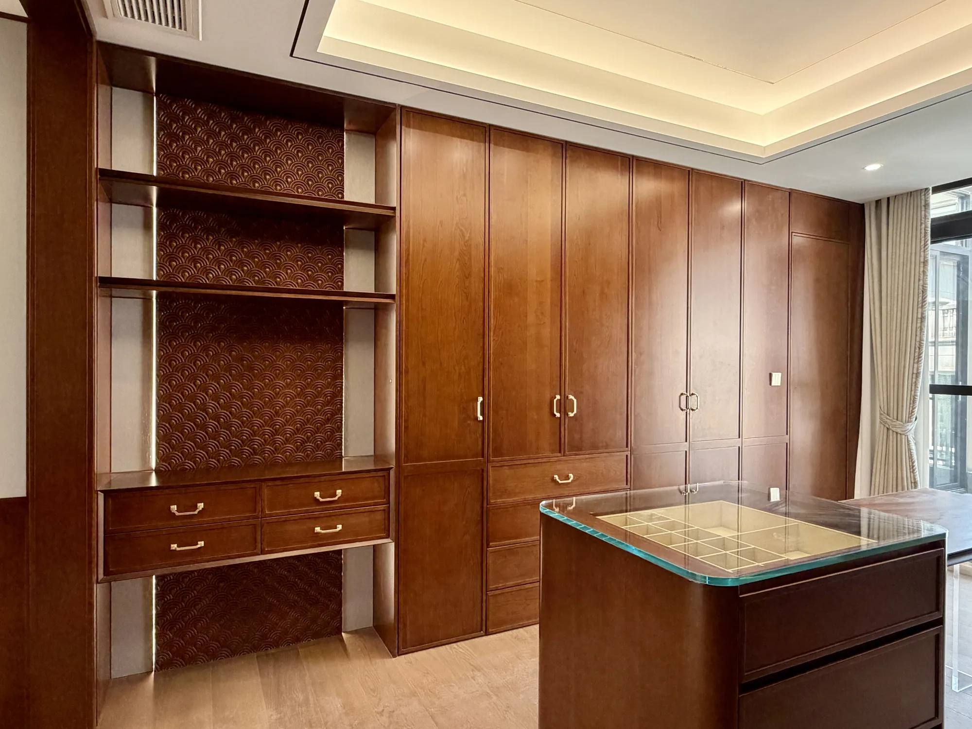 Walnut home office with display shelves, island desk and fitted cabinetry