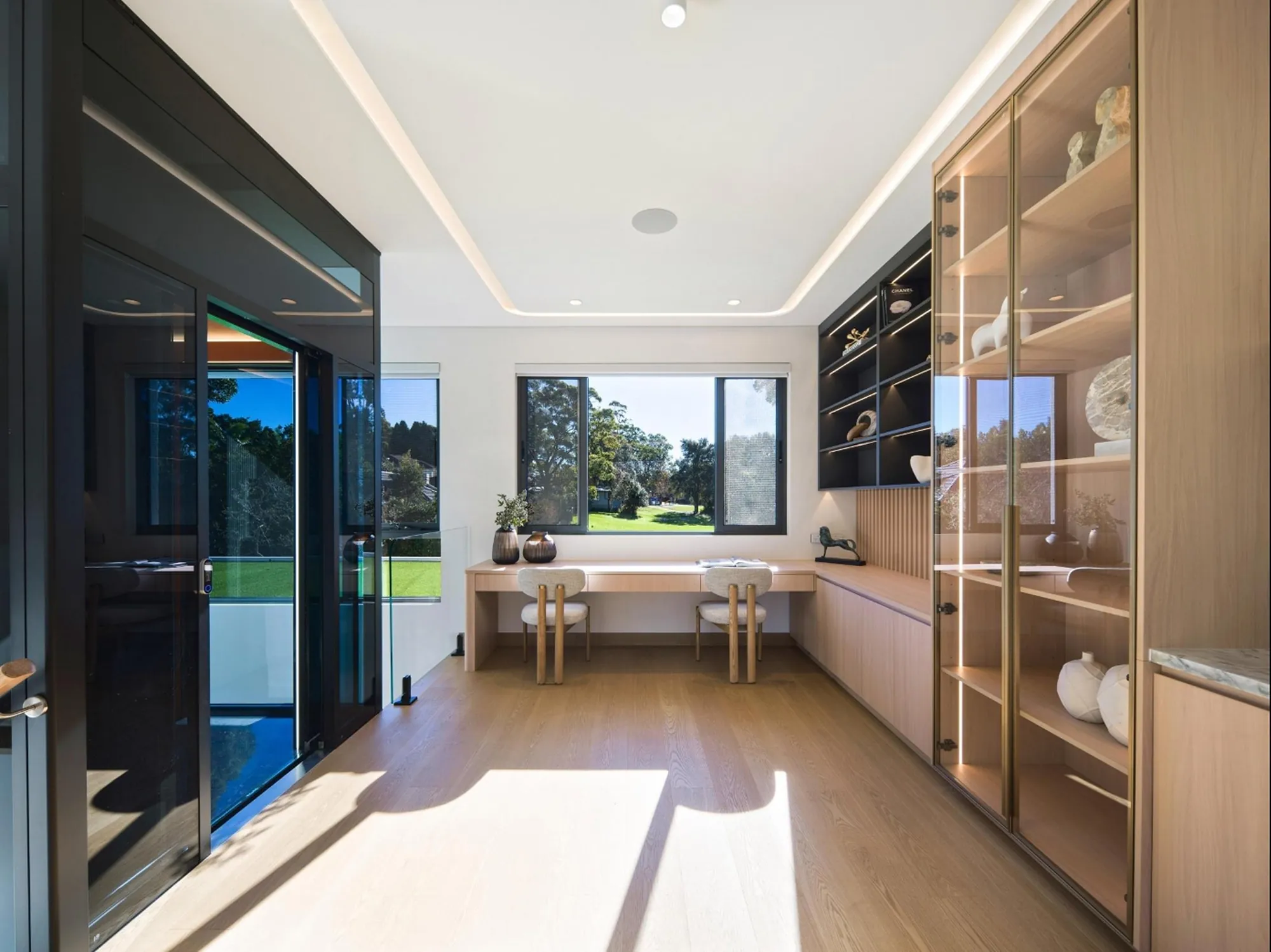 Glass display cabinet and slim dark shelving in the study