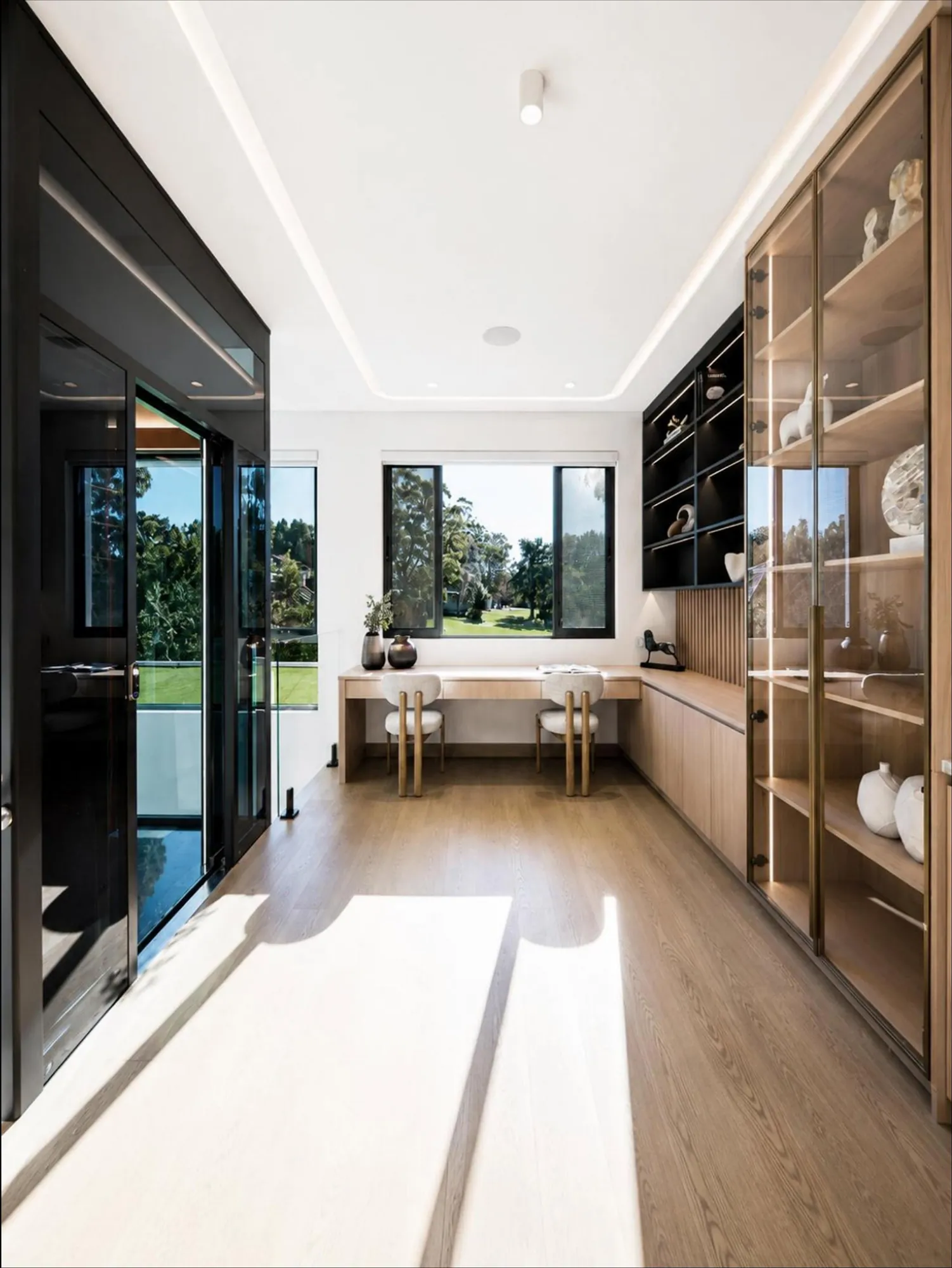 Study nook with window desk, warm timber storage and glass display doors