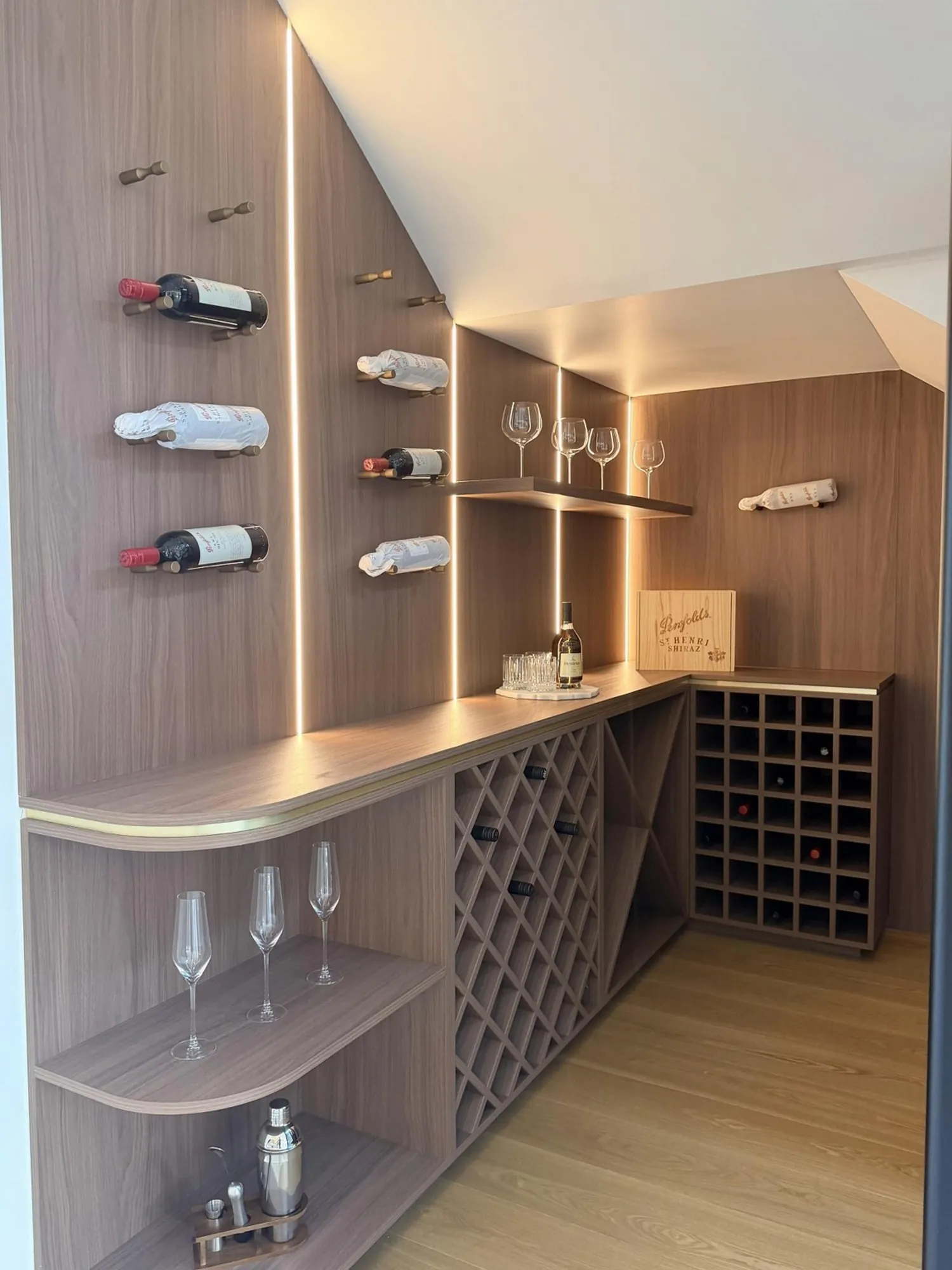 Walnut wine cabinet with curved shelves, bottle storage and integrated lighting