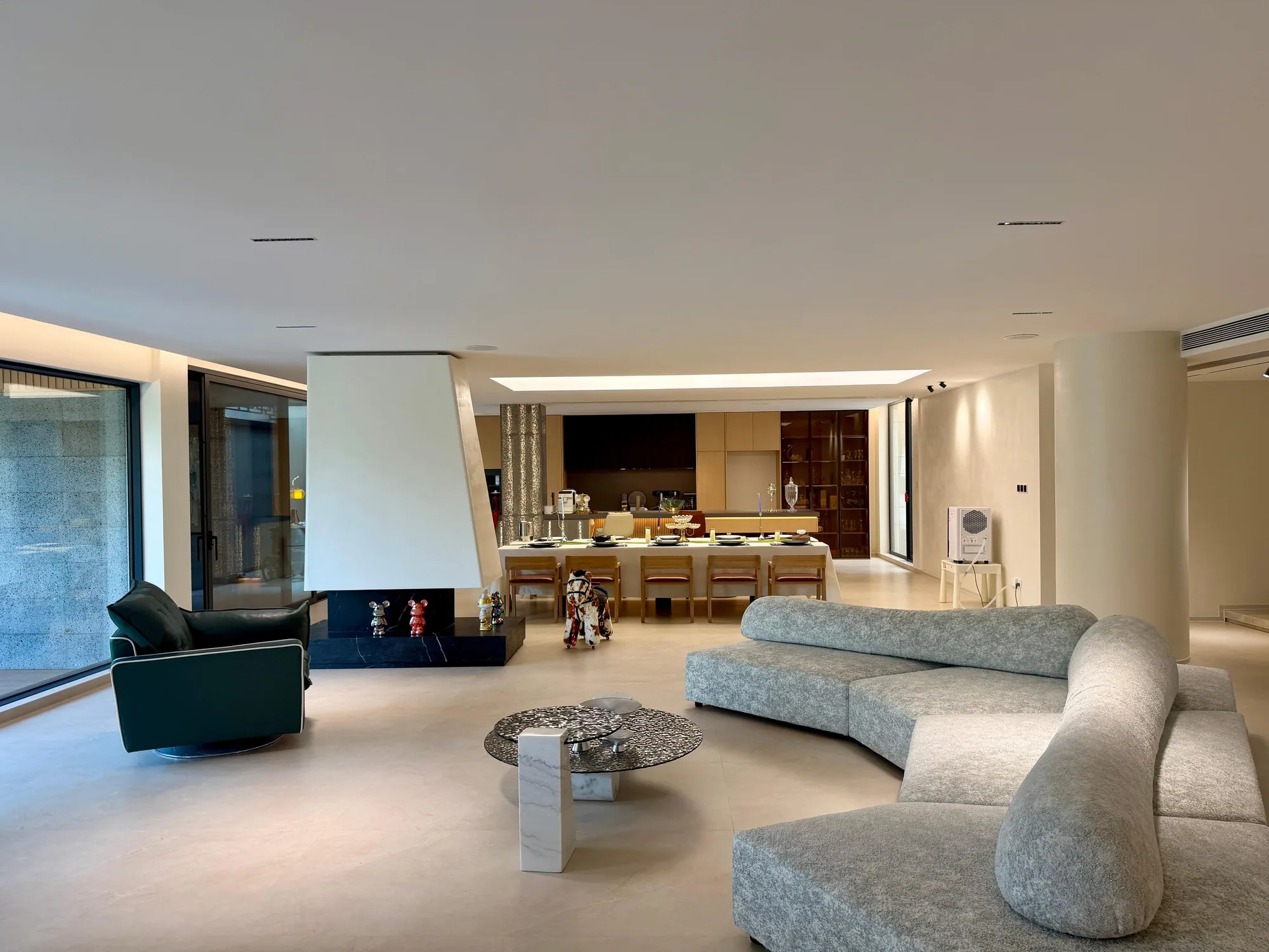 Open-plan Nigeria villa interior with black-walnut joinery, pale stone floors and connected living and dining areas