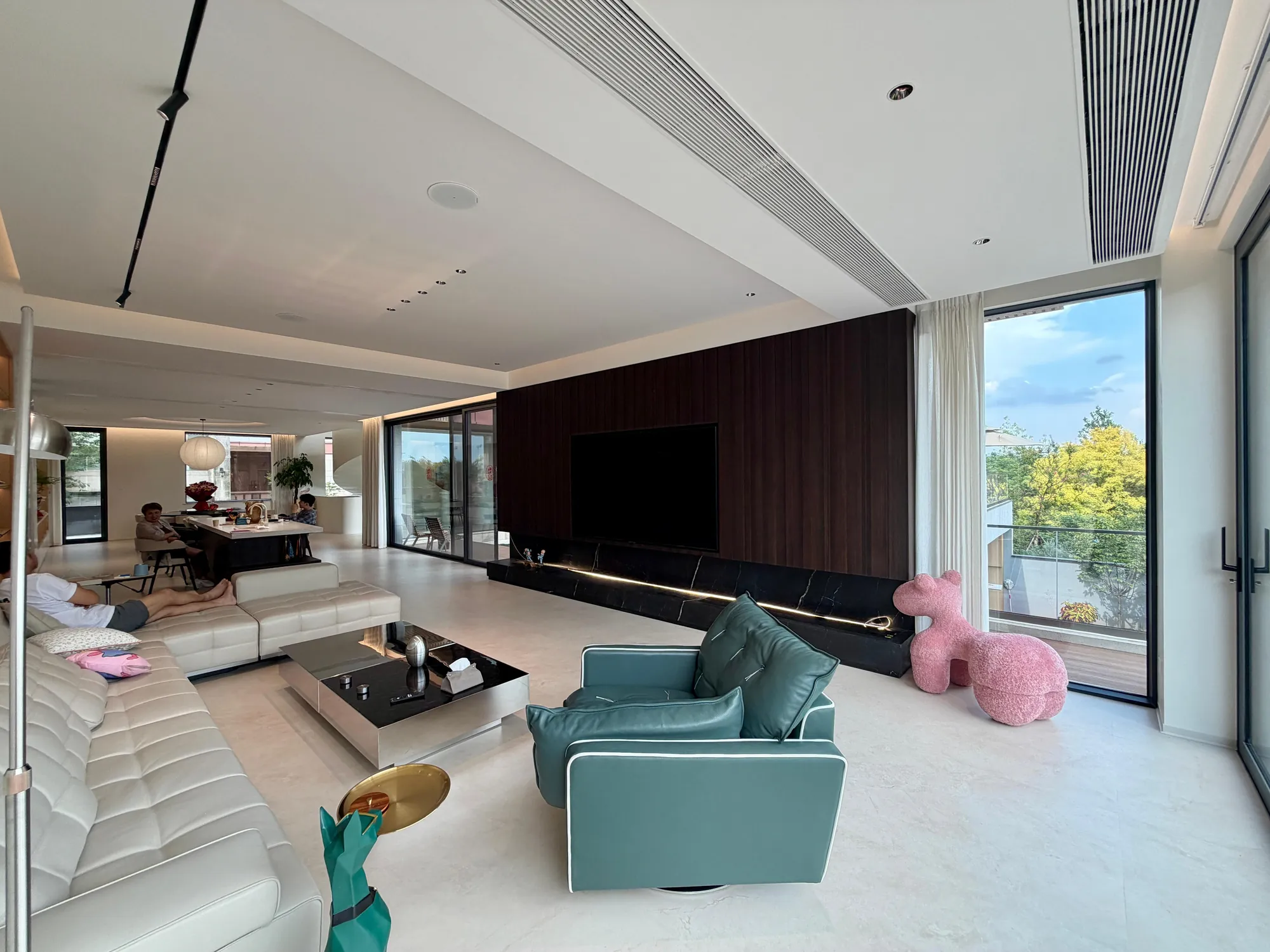 Living room with full-height black-walnut media wall and low neutral seating
