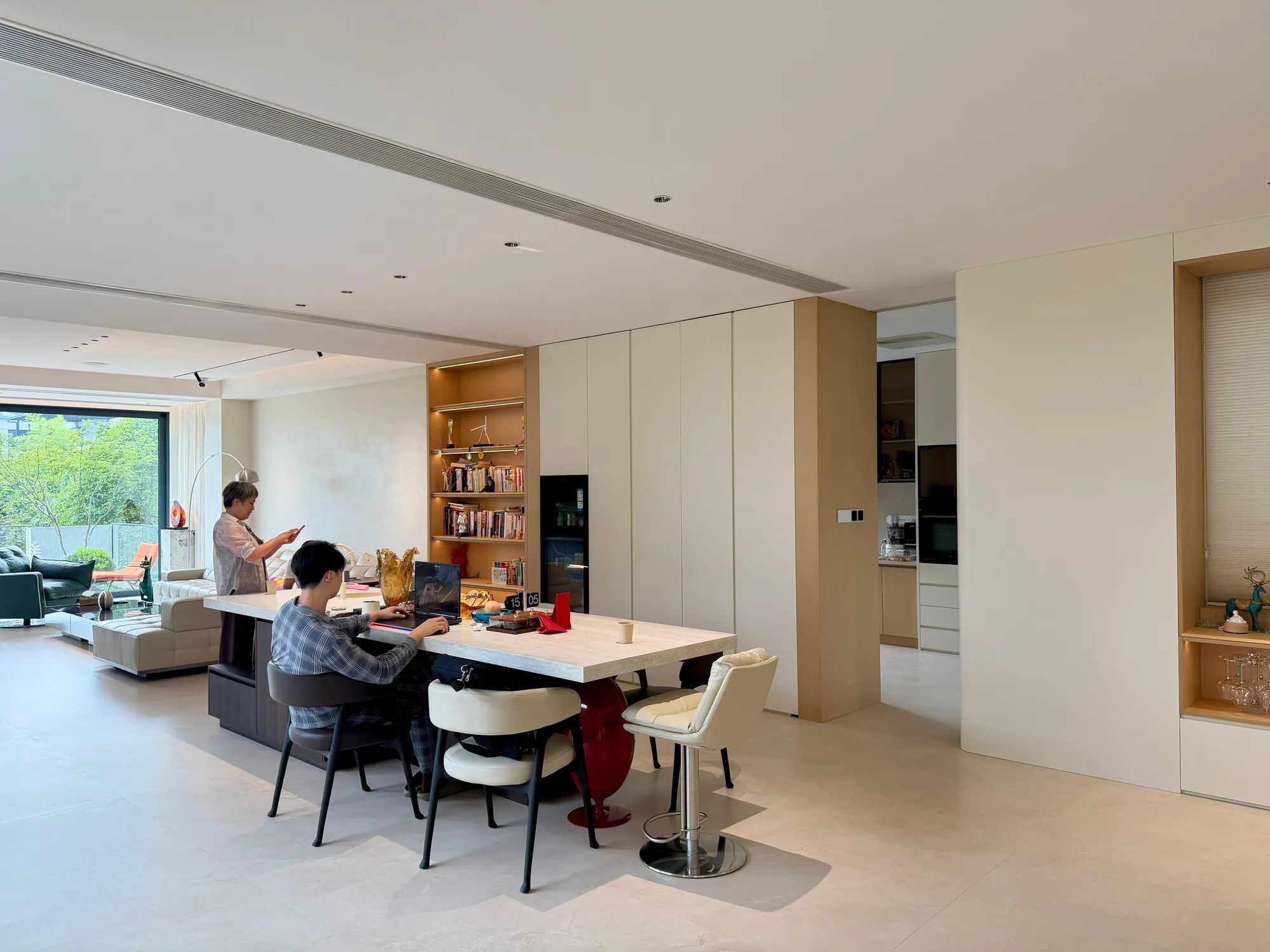 Open study and library with fitted walnut shelving and a long worktop