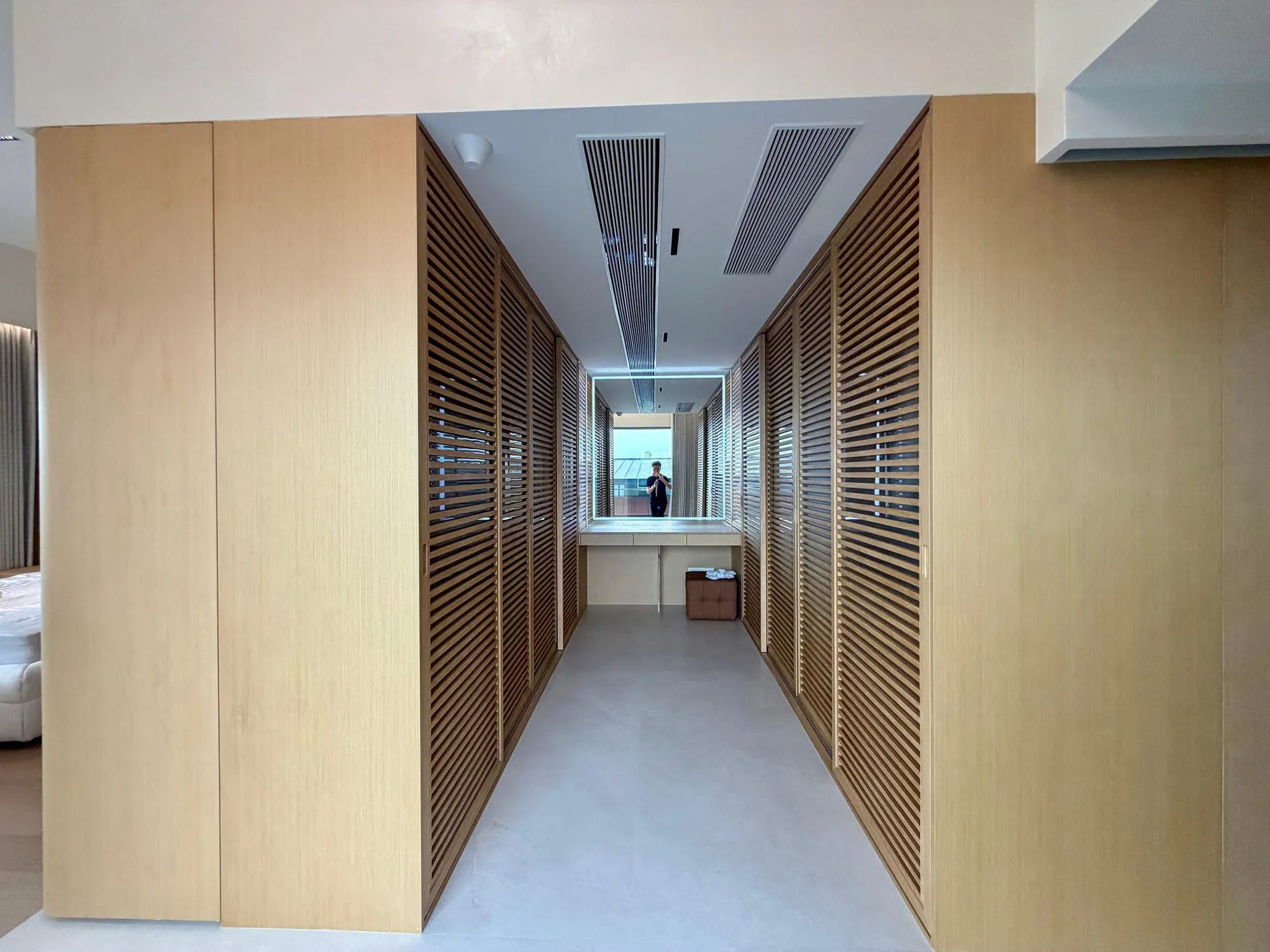 Walk-in dressing room with full-height louvred timber wardrobes