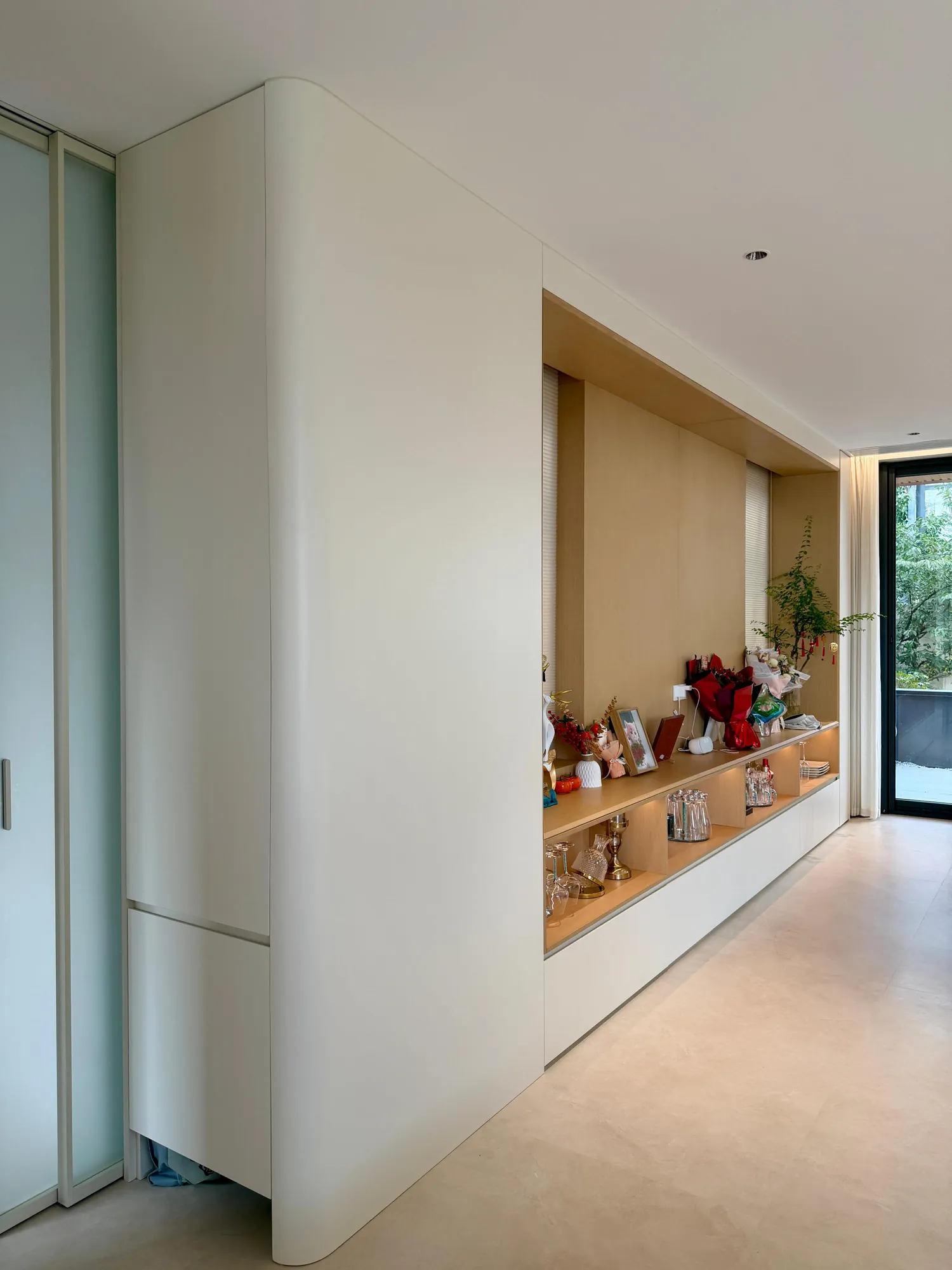 Curved built-in credenza with open shelves and integrated backlighting