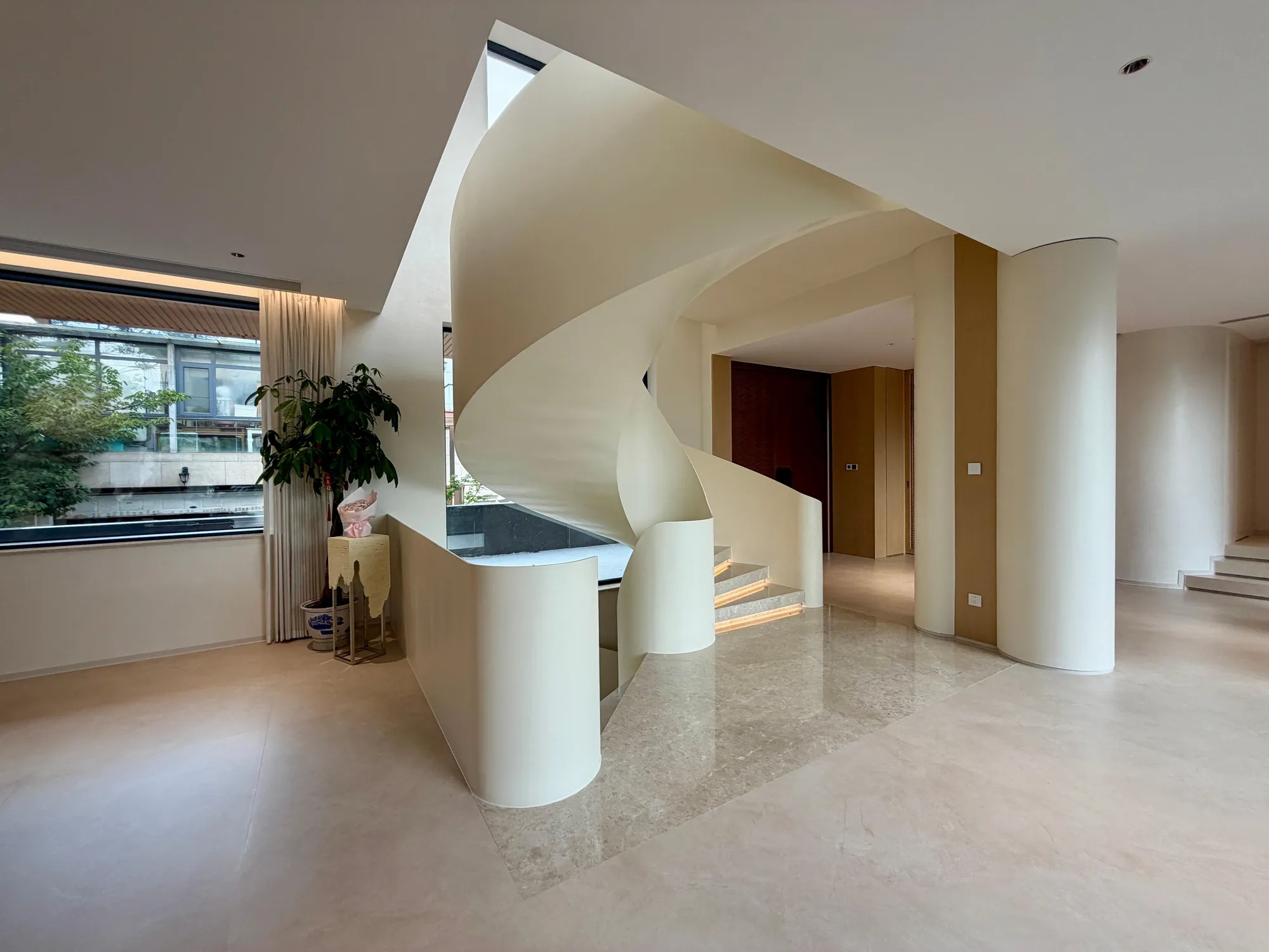 Sculptural white staircase connecting the public and private levels of the villa