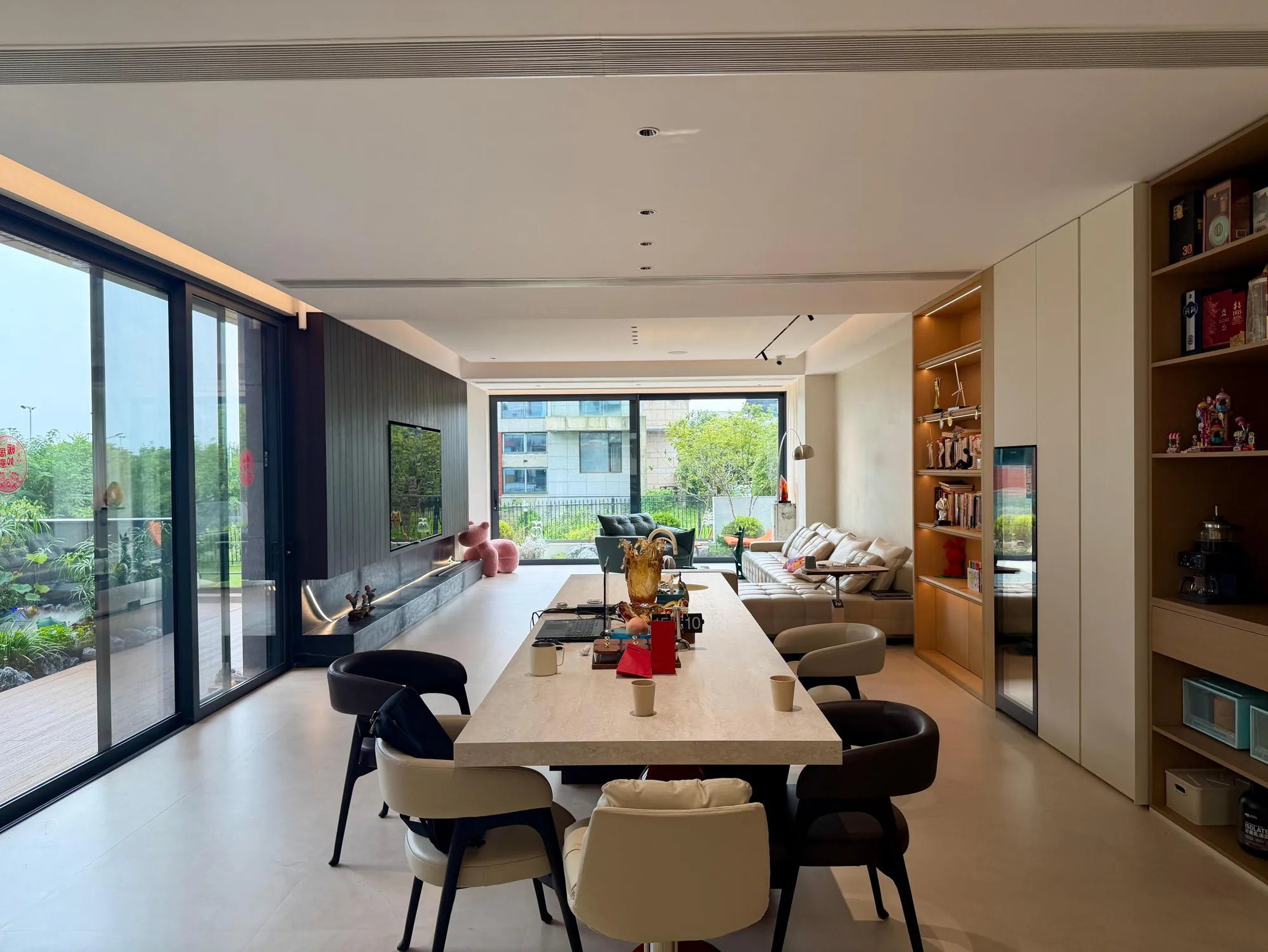 Dining table beside warm timber display and service cabinetry