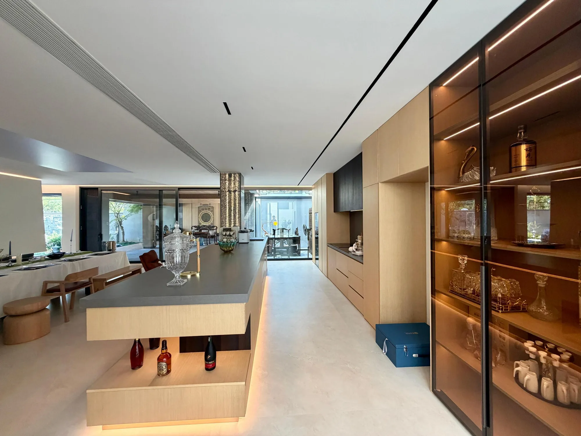 Dark glass display cabinet and illuminated island joinery