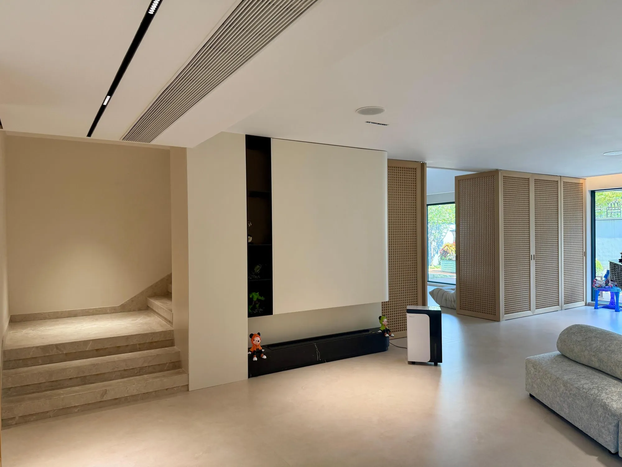 Installed media wall with pale panels and dark vertical storage