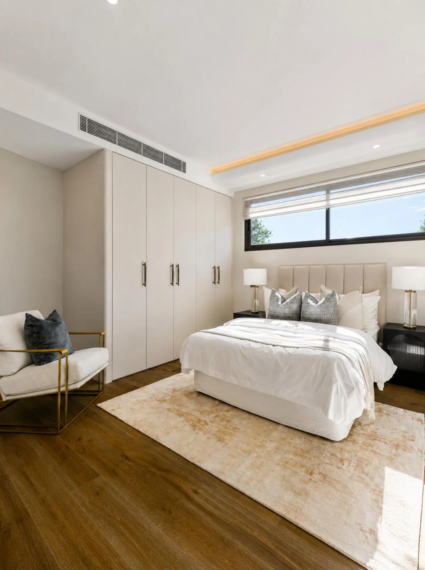 Warm contemporary bedroom with pale wardrobe wall and window seating