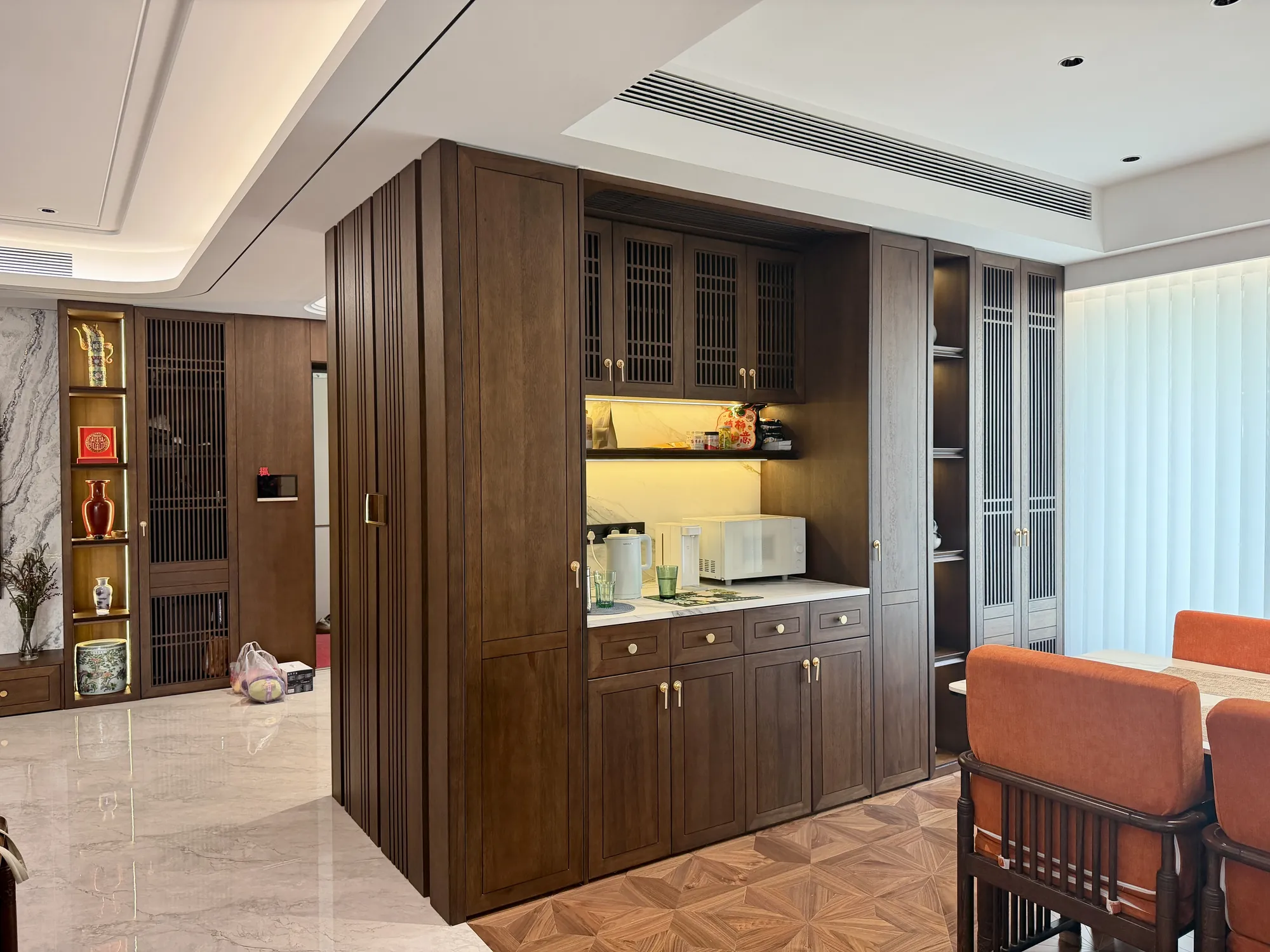 Kitchen with full-height walnut cabinets, grille-front doors and brass details