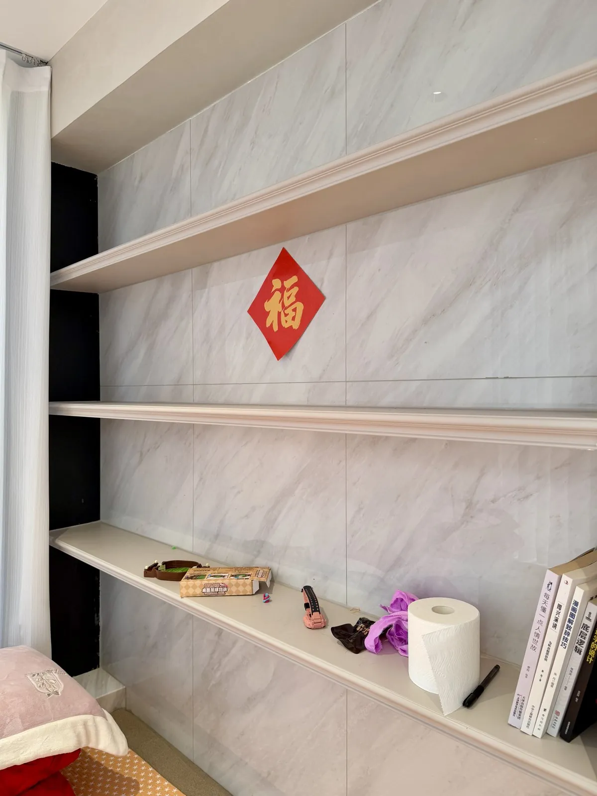 Detail of walnut display shelving with marble backing and red accent