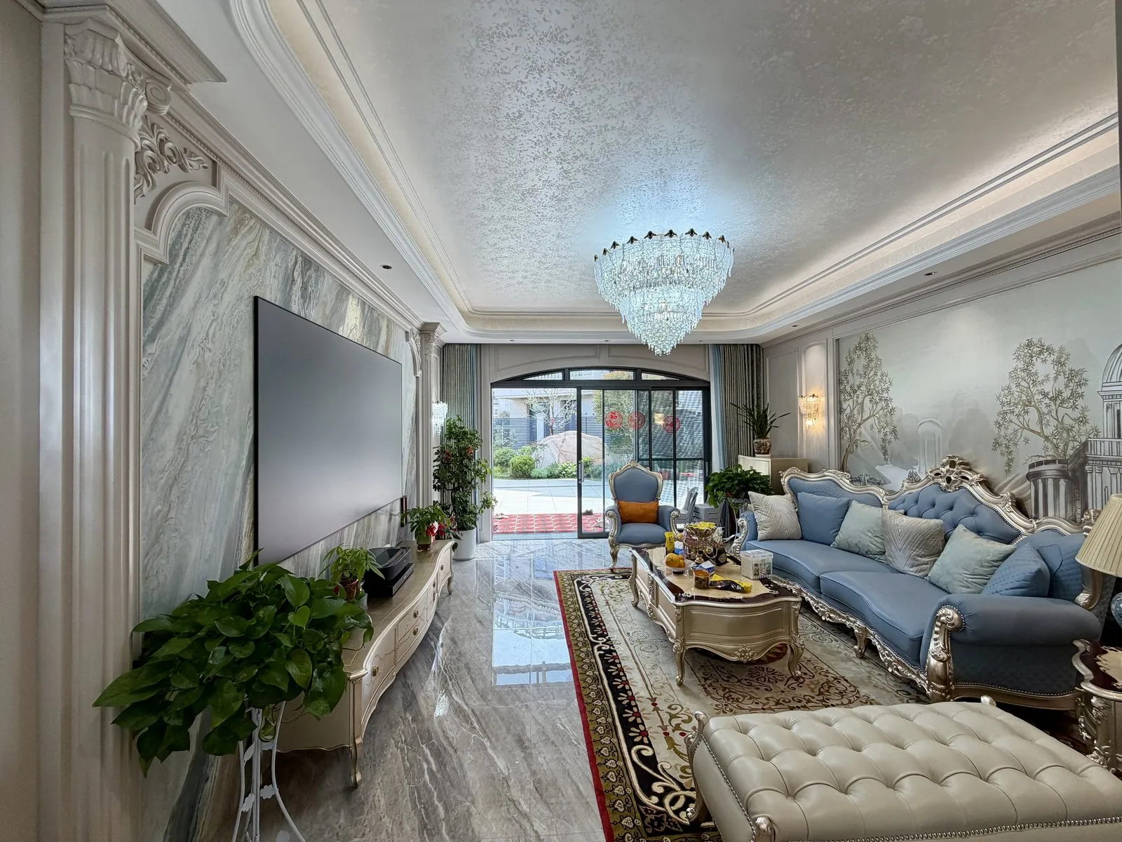 Wide California villa living room with painted wall panels, marble feature wall and blue seating