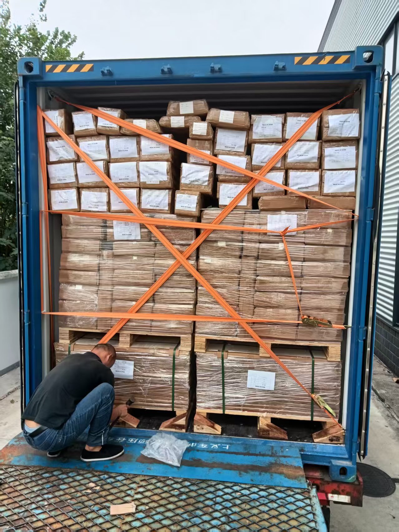 Labeled project packages secured inside an export shipping container
